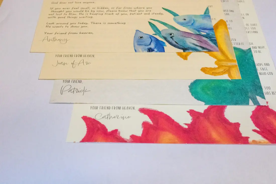 Four saint letters fanned out, signed by Anthony, Joan of Arc, Patrick, and Catherine — each ends 'Your friend from heaven'