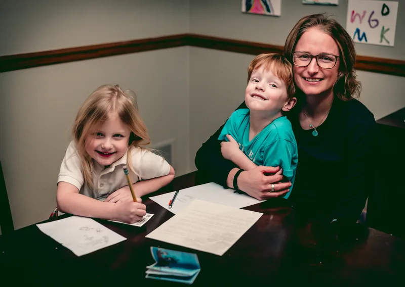 Val and her kids hand-drawing Letters from Heaven saint illustrations at the kitchen table