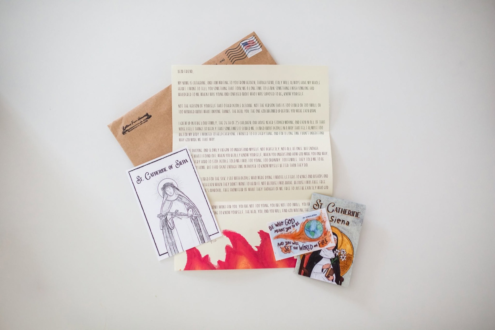 Everything in the April envelope: St. Catherine's hand-drawn letter, prayer card, sticker, and zine