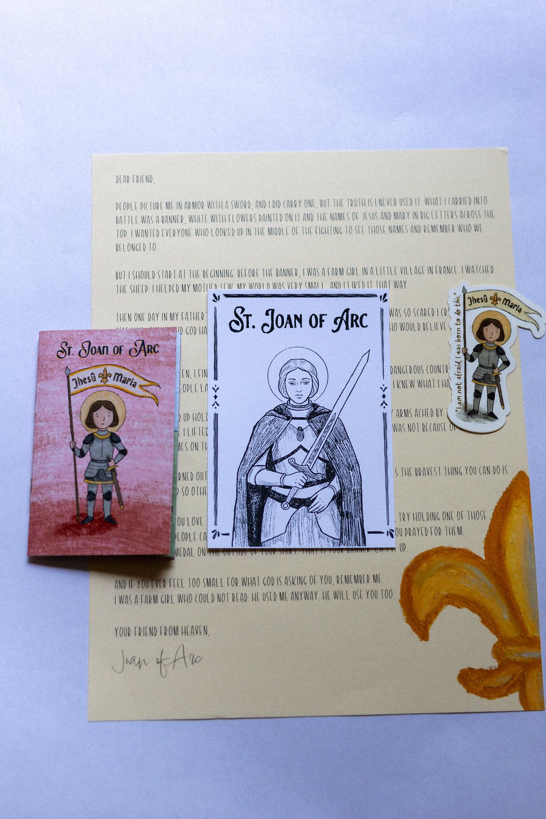 Everything in the May envelope: St. Joan of Arc's hand-drawn letter, prayer card, sticker, and zine